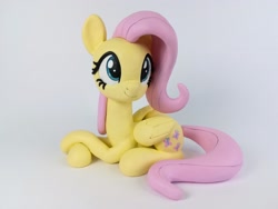 Size: 2560x1920 | Tagged: safe, artist:sparkle40559933, fluttershy (mlp), equine, fictional species, mammal, pegasus, pony, feral, friendship is magic, hasbro, my little pony, 2021, commission, eyelashes, feathered wings, feathers, female, figurine, folded wings, hair, high res, irl, mane, mare, photo, pink hair, pink mane, pink tail, sitting, smiling, solo, solo female, tail, wings